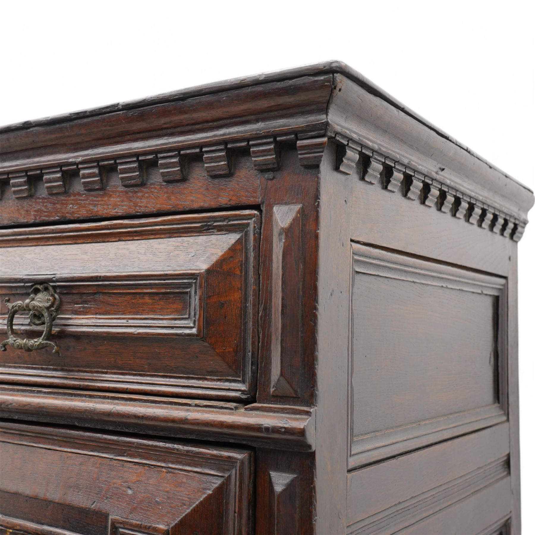 17th century oak chest on stand, moulded cornice over block work frieze, the upper section fitted with three long drawers each decorated with applied geometric mouldings and faceted panels, panelled sides with moulded frame, the stand fitted with two drawers, on five turned supports united by plan flat stretchers, terminating to turned feet