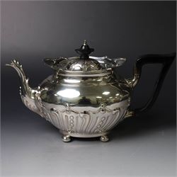 Edwardian silver three piece tea service, comprising teapot, twin handled open sucrier and a cream jug, each of oval form with embossed scrolling decoration and upon four bun feet, the teapot with ebonised wooden handle and finial, hallmarked Thomas Bradbury & Sons Ltd, Sheffield 1903, teapot H16cm