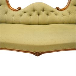 Victorian mahogany framed double ended chaise longue, serpentine button upholstered back with raised scrolled ends, padded arms and stuff-over seat upholstered in green fabric, carved showframe with foliate terminals and scroll supports, on short cabriole legs with brass castors