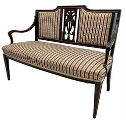 Edwardian mahogany framed three-piece salon suite - two-seat sofa, stepped cresting rail over acanthus and scroll carved pierced splat, upholstered in striped fabric (W124cm, H87cm, D62cm); and a pair of matching armchairs (W60cm) 