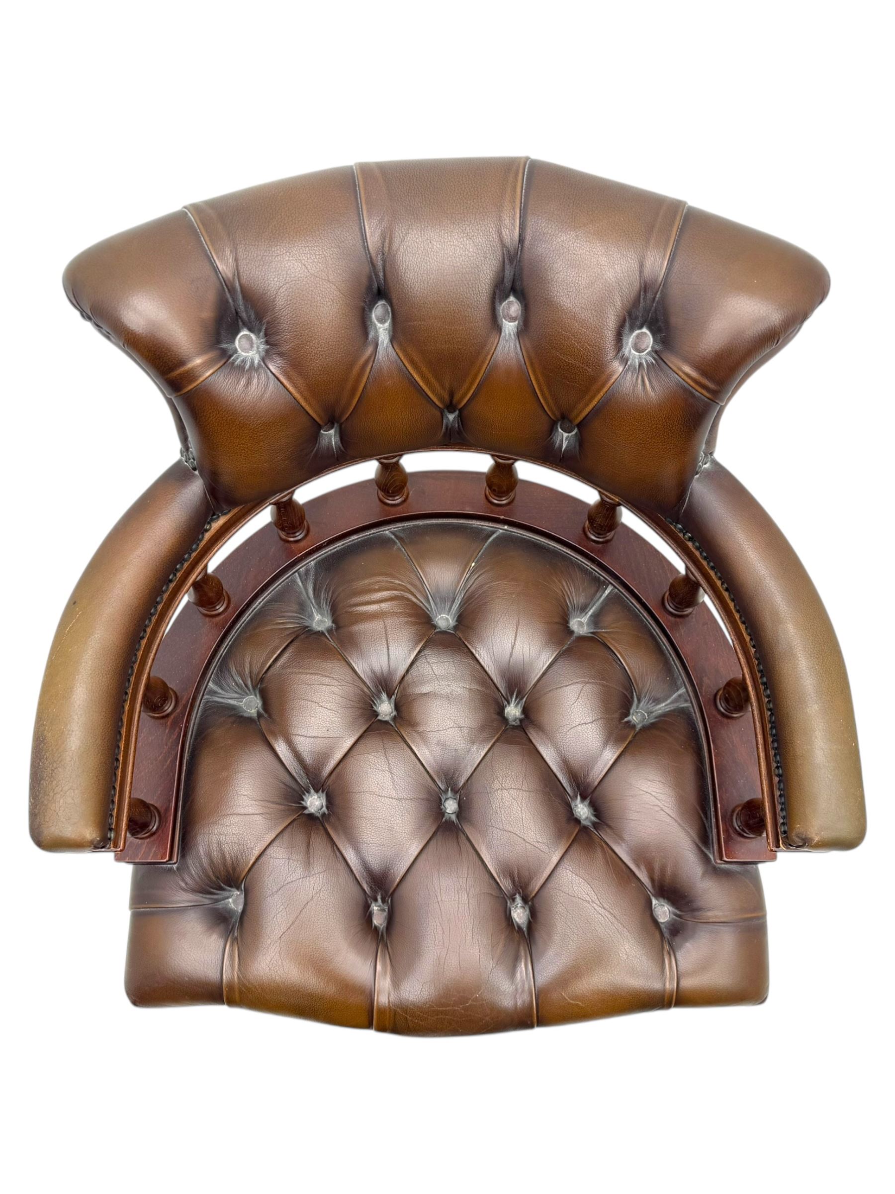 Mahogany framed swivel Captains desk chair, upholstered in brown buttoned leather, turned supports and swivel base on castors
