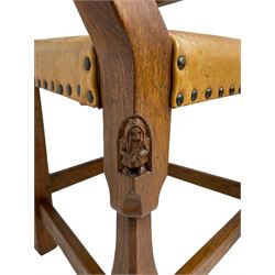 Gnomeman - set four oak dining chairs, panelled backs with tan hide upholstered seats with studwork, raised on shaped chamfered supports united by stretchers, each carved with Gnome signature, one carver and three side chairs, by Thomas Whittaker of Littlebeck