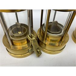 Four miners lamps, comprising Clanny miners lamp, with flip top and gauze protected by three rods, stamped E.T.W E-3, lamp with a gauze chamber protected by three rods, and two E. Thomas & Williams Ltd lamps, tallest example H26cm