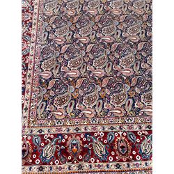 Old Persian Meshed indigo ground carpet, the field profusely decorated with repeating boteh motifs, the crimson border with a trailing stylised plant pattern, guarded by six geometric design bands