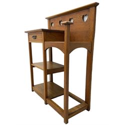 Arts and Crafts period golden oak hallstand, raised back with pierced heart decoration, fitted with glove drawer over two shelves, beside umbrella stand