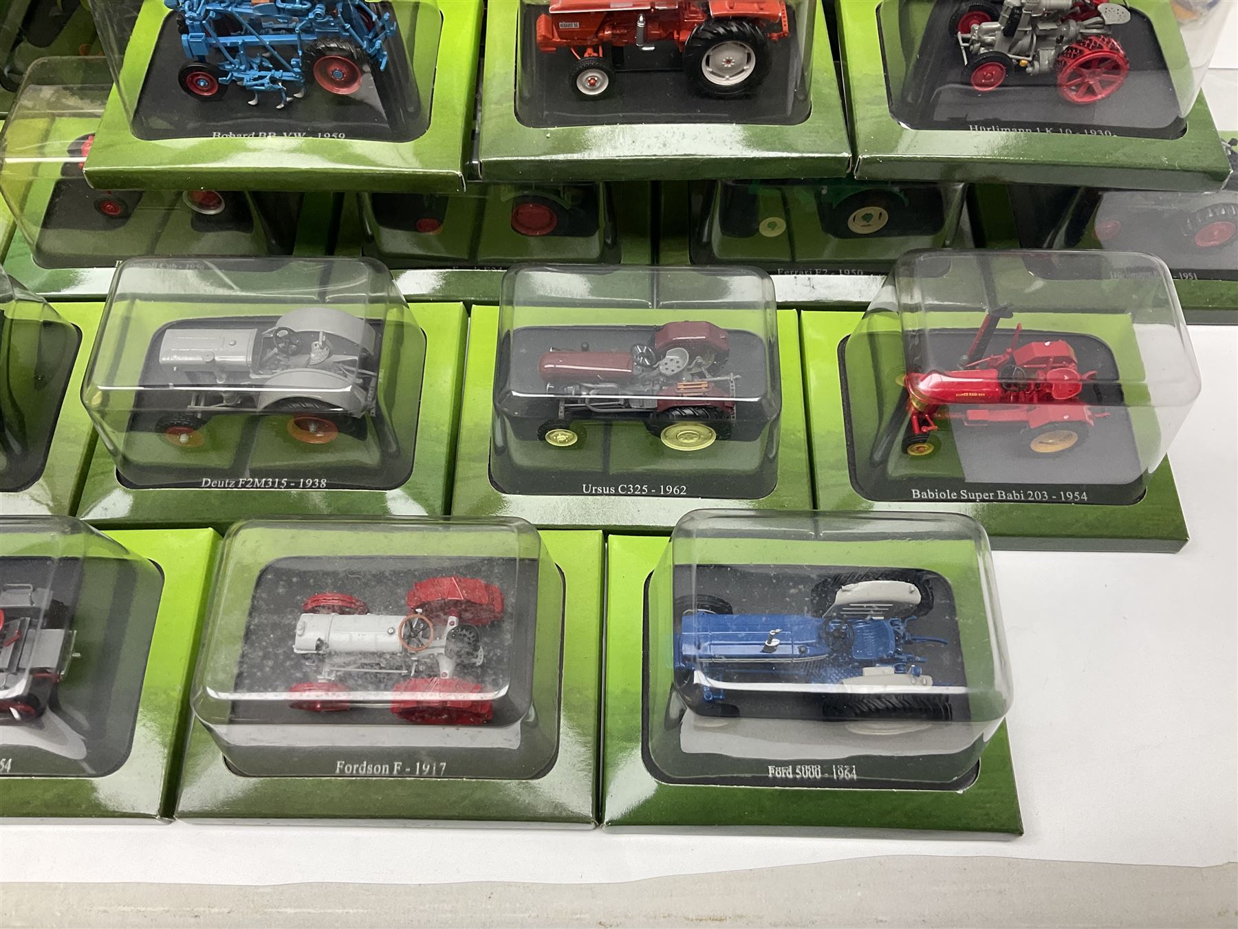 Eighteen issues of Tractors and The World of Farming magazine, together with sixty diecast tractors, all in original packaging, in three boxes 