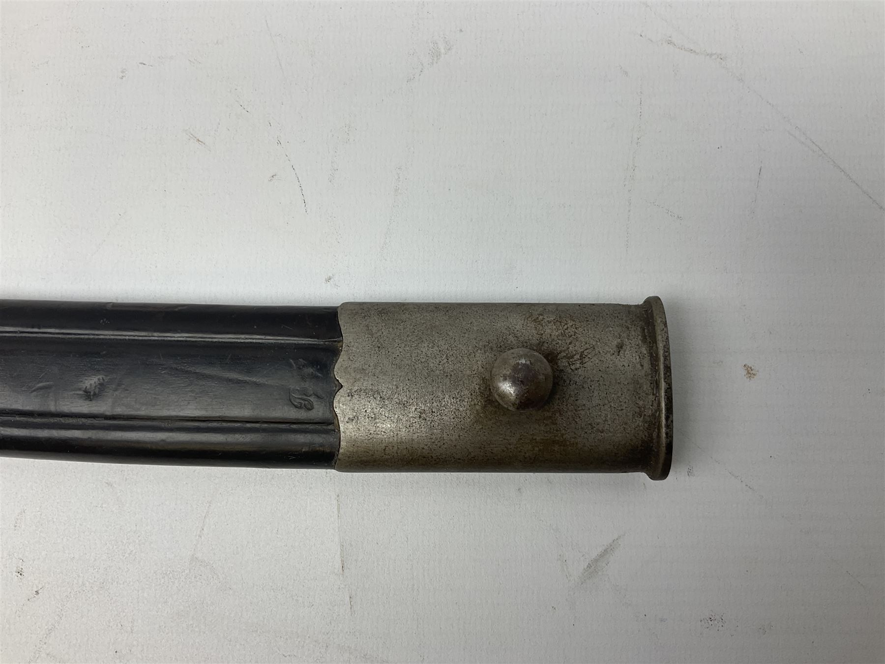 Turkish Model 1874 sword bayonet with 57.5cm curving steel fullered blade and chequered black grip, in steel mounted leather scabbard L75.5cm overall