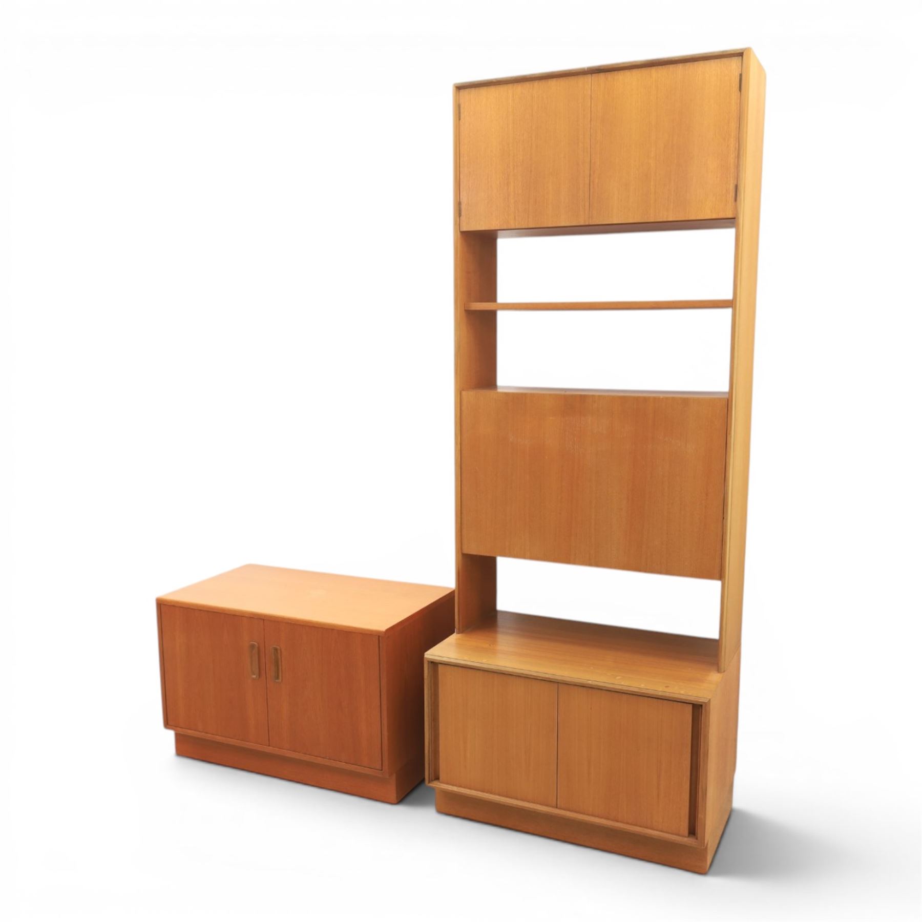 G Plan - Mid 20th century teak units, comprising tall shelving unit with cupboard sections, fall front and open shelves, together with a low twin-door cupboard unit, on plinth bases

Low unit: H 53cm, D 46cm, W 81cm
Tall unit: H 199cm, D 46cm, W 76cm