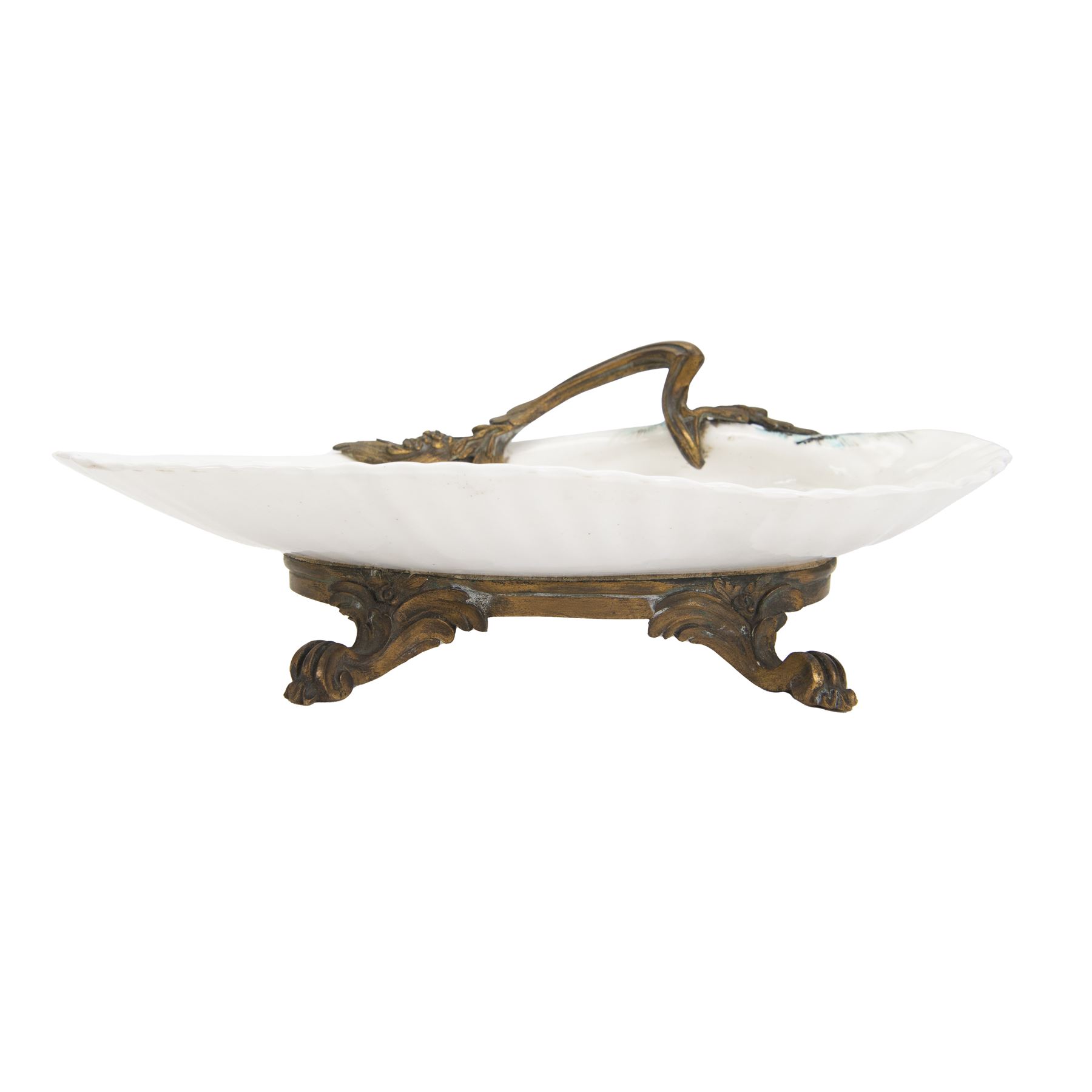 18th century porcelain dish, attributed to Chantilly, circa 1740-1750, with later ormolu mounted handle and feet, the dish of moulded shell form, painted in the Kakiemon pallet with an exotic bird and grasshopper amidst flowers and foliage, with foliate ormolu handle, and upon three scrolling foliate feet, possible obscure Chantilly mark beneath, including handle H10cm W31cm

A letter from the Ashmolean Museum accompanied the dish when it entered the current vendor's family collection. In the letter, Dr. Impey noted that the painting is European, possibly Dutch. The general consensus was that the shell dates to the 18th century, with the ormolu mounts likely added in the 19th century. However, the factory of origin remained unidentified. The letter was signed by Ian Lowe in 1974. Further consultation at the time with four members of staff at the Victoria and Albert Museum yielded differing opinions, with suggestions including Chantilly and Bow. The piece has been attributed to Chantilly partly due to what appears to be a partially obliterated horn motif beneath.