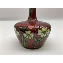 Three Minton Secessionist vases, with tube-lined stylised flower decoration, two upon a red ground and third upon a purple ground, all with printed mark to base 'Minton Ltd, No. 33', H13cm