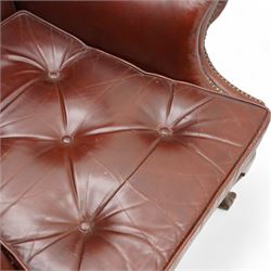 Georgian design leather wingback armchair, deep-buttoned burgundy leather upholstery with rolled arms, studded detail along the edges, raised on cabriole supports terminating in claw and ball feet
