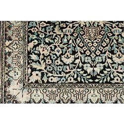 Persian style rug, central floral medallion surrounded by intricate palmetters, vines and rosettes, navy blue ground with ivory and pink highlights