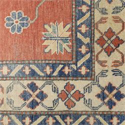 Persian Kazak vermillion ground rug, decorated with a foliate pole medallion with surrounding geometric and plant motifs, the guard bands with repeating floral and geometric design
