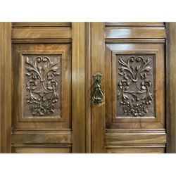 Edwardian walnut combination breakfront triple wardrobe, projecting cornice over cushioned and fluted frieze, central fielded panelled cupboard carved with foliate decoration above two short and three long drawers, flanked by two bevelled mirror doors enclosing hanging hooks with single drawers to base, retailed by J Tonks & Sons, Scarborough