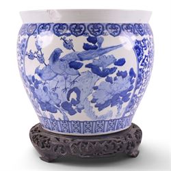 20th century blue and white fishbowl planter, decorated with birds in blossoming branches, internally decorated with goldfish, upon a wooden base, H44cm