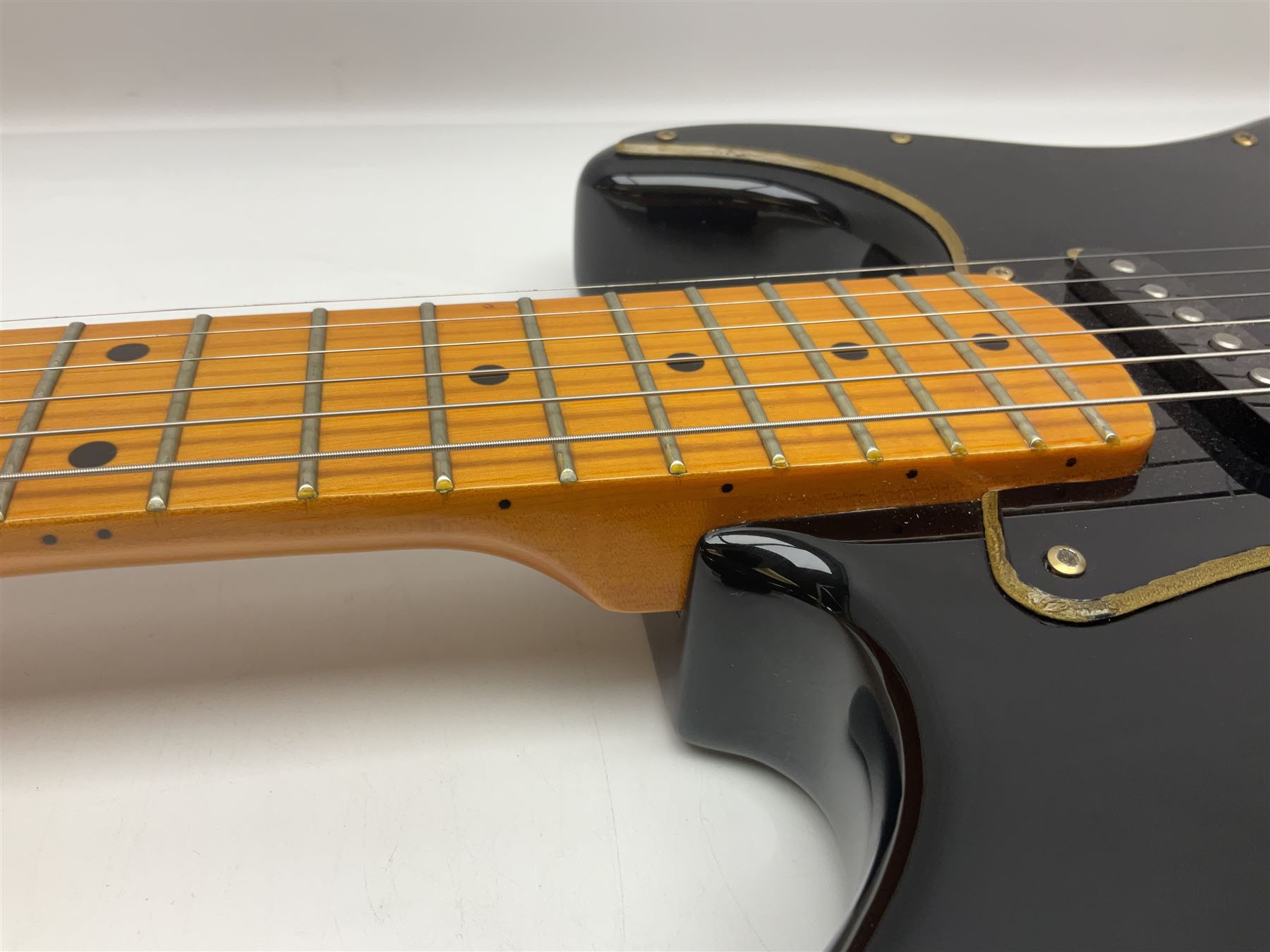 Copy of a Fender Stratocaster electric guitar in black with Wilkinson bridge, lock-in tuners, synchronised tremolo and various patent numbers; L99cm; in hard carrying case with strap and digital tuner