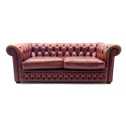 Two seat Chesterfield sofa, upholstered in a studded and deep buttoned red leather, raised on bun feet 