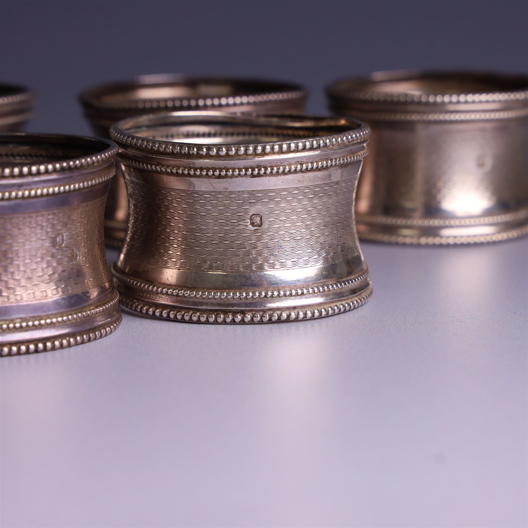 Six early 20th century French silver napkin rings, each with engraved initials, stamped with Minerva mark for 950 standard silver and maker's mark for Claude Doutre Roussel 