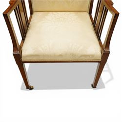Arts & Crafts period inlaid mahogany framed armchair, swept arms with satinwood-strung supports over back and sprung seat upholstered in cream foliate damask fabric, on square tapering supports with castors