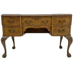 Mid 20th century walnut kneehole desk, three sectional inset leather top with carved foliate mould, fitted with five drawers, on shell carved cabriole supports with ball and claw feet