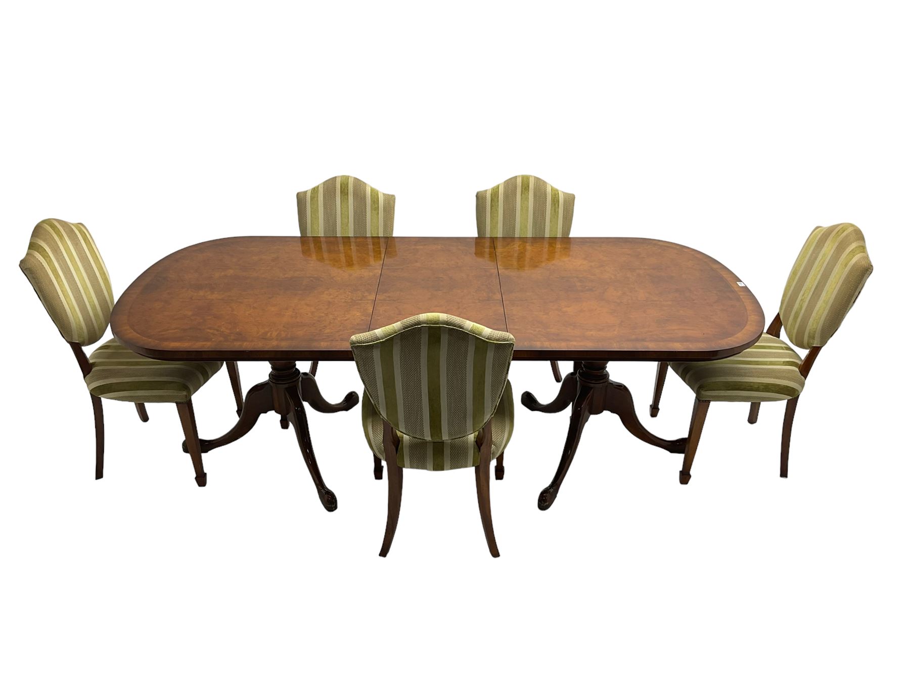 Regency design walnut twin pedestal extending dining table, rectangular burr top with rounded corners and crossbanding, raised on turned vasiform columns with tripod base, with additional leaf (D107cm W184cm/230cm, H76cm); and set eight (6+2) shield back dining chairs, upholstered in striped laurel green fabric, raised on tapering supports with spade feet, retailed by Geoffrey Benson