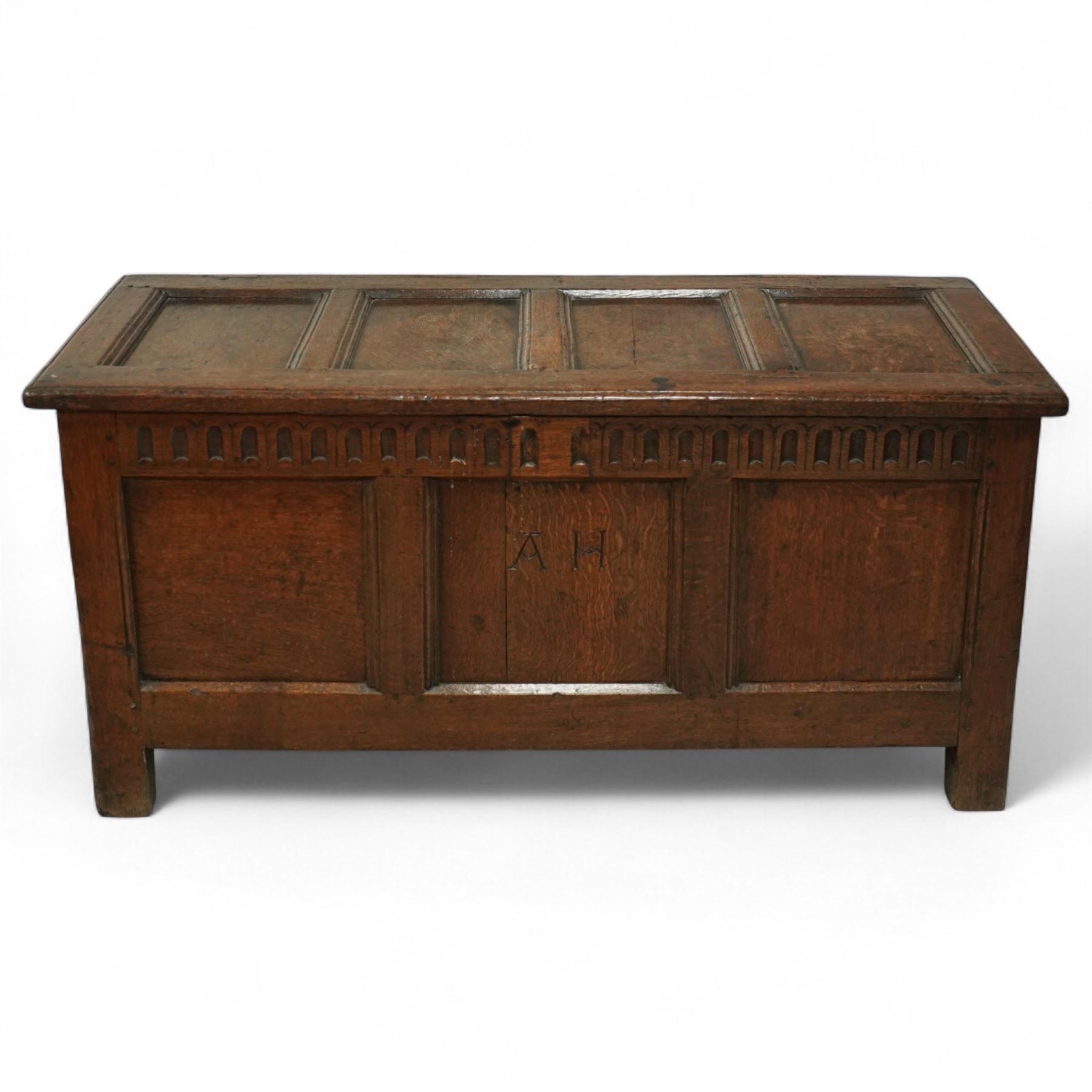 18th century and later oak coffer, the hinged plank top above a panelled front carved with lunette frieze, plain stiles and rails, carved with initials ‘AH’, pegged construction throughout