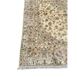 Persian Kashan ivory ground rug, the central floral medallion surrounded by interlacing branches and stylised flower head motifs, guarded border decorated with a scrolling foliate pattern