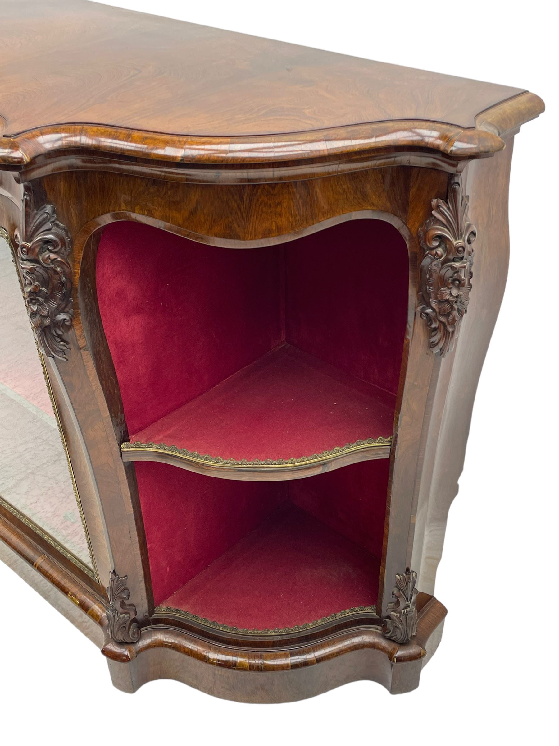 19th century rosewood buffet credenza, bombe form with shaped and moulded top, two central glazed doors with foliate moulded gilt slips, the red fabric-lined interior fitted with a single shelf, flanked by open shelves with raised gilt metal lips, the uprights decorated with shell and flower head carved cartouche mounts, acanthus leaf scroll carved lower mounts, on shaped and moulded plinth base 