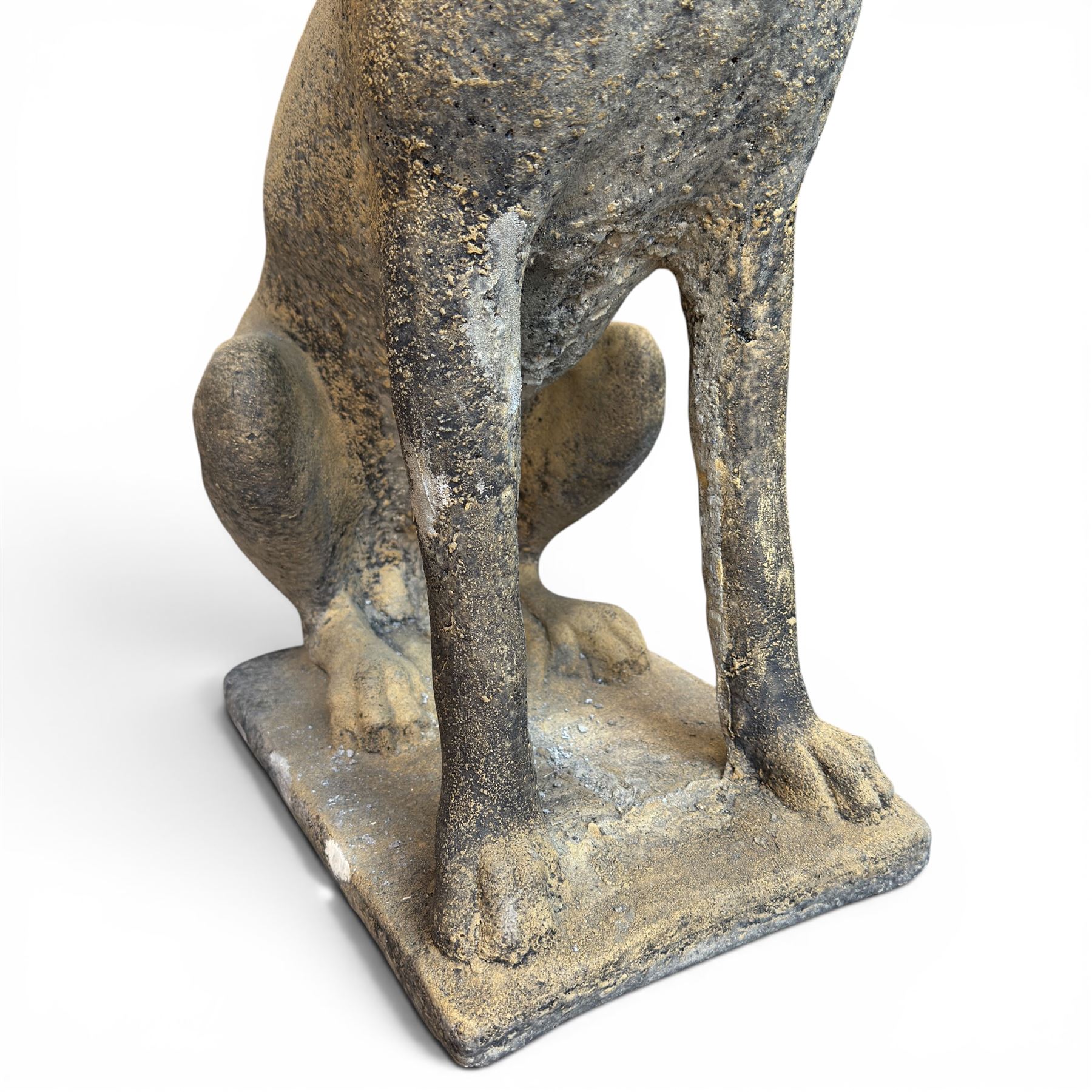 Pair of cast stone hunting pointer dogs in seated poses raised on rectangular bases, in antique weathered finish