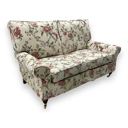 Steed Upholstery - 'Knightsbridge' two seater sofa, upholstered in cream fabric with pink and green floral design, loose back and seat cushions, raised on mahogany supports with brass castors
