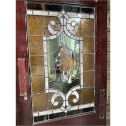 Two early to mid 20th century timber doors, set with lead framed stained glass panels depicting agricultural worker and horse
