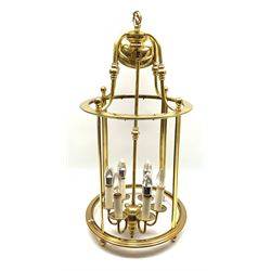 A brass hall lantern, the cylindrical body with glass panels and central six branch fitting, overall approximately H91cm. 