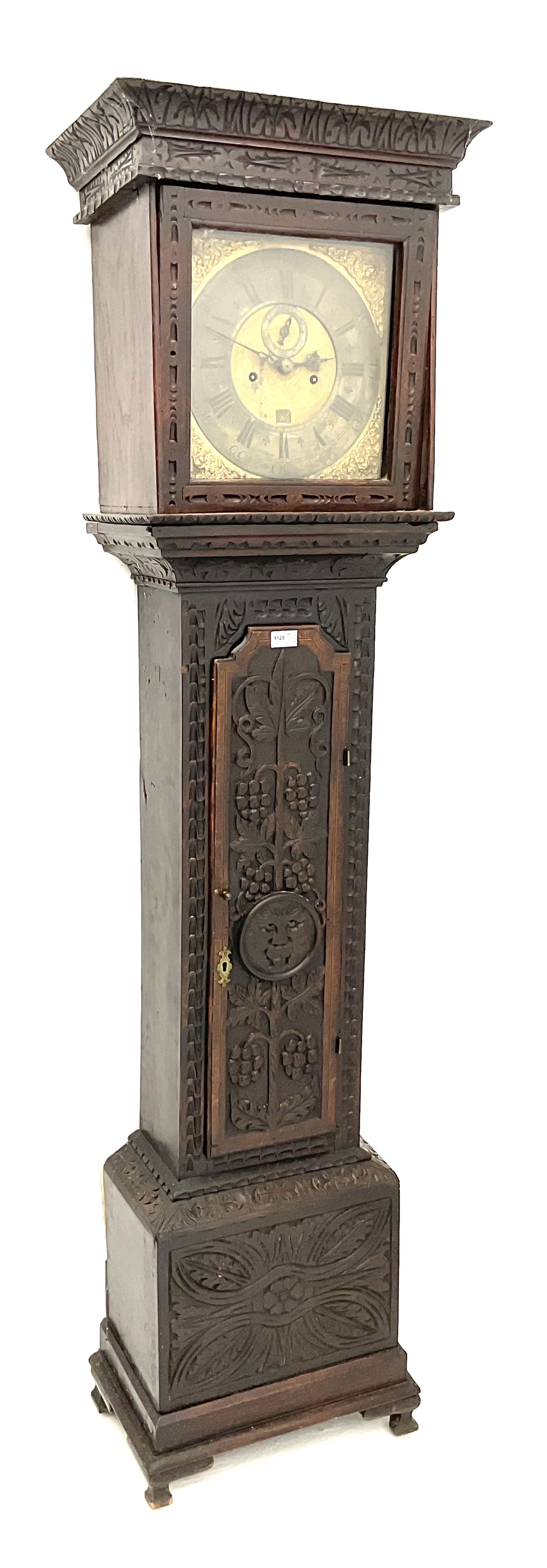 18th century oak longcase clock with later carving, the hood with projecting cornice over square glazed door, trunk door carved with tree of life, foliage carved base, on ogee bracket feet, brass dial with Roman chapter ring and subsidiary seconds and calendar aperture, ornate mask cast spandrels, twin train driven movement striking on bell 