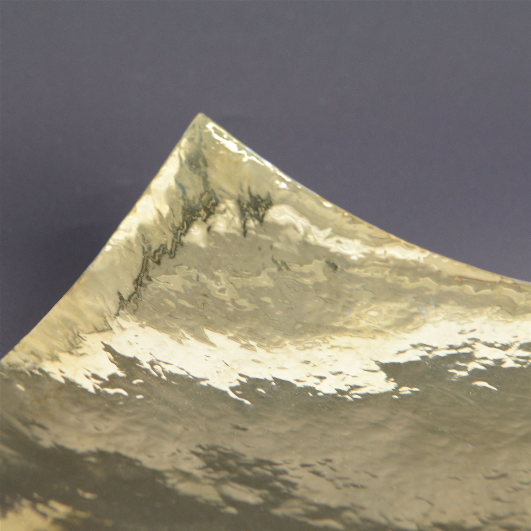 Modern silver bowl, of square concave form, with gilt interior and gilt spiral decoration to underside, with planished decoration throughout, upon four column feet, hallmarked Jonathan Braganza, London 2013, H5cm, W18cm