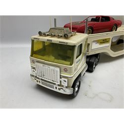 American Nylint large scale tin-plate car transporter L59cm carrying a Testor Toys plastic car; Tonka tin-plate mobile crane; boxed Sarony Cigarettes tin-plate roulette game with rules; and Japanese style tin-plate box, the lid inset with a revolving poker dice game (4)