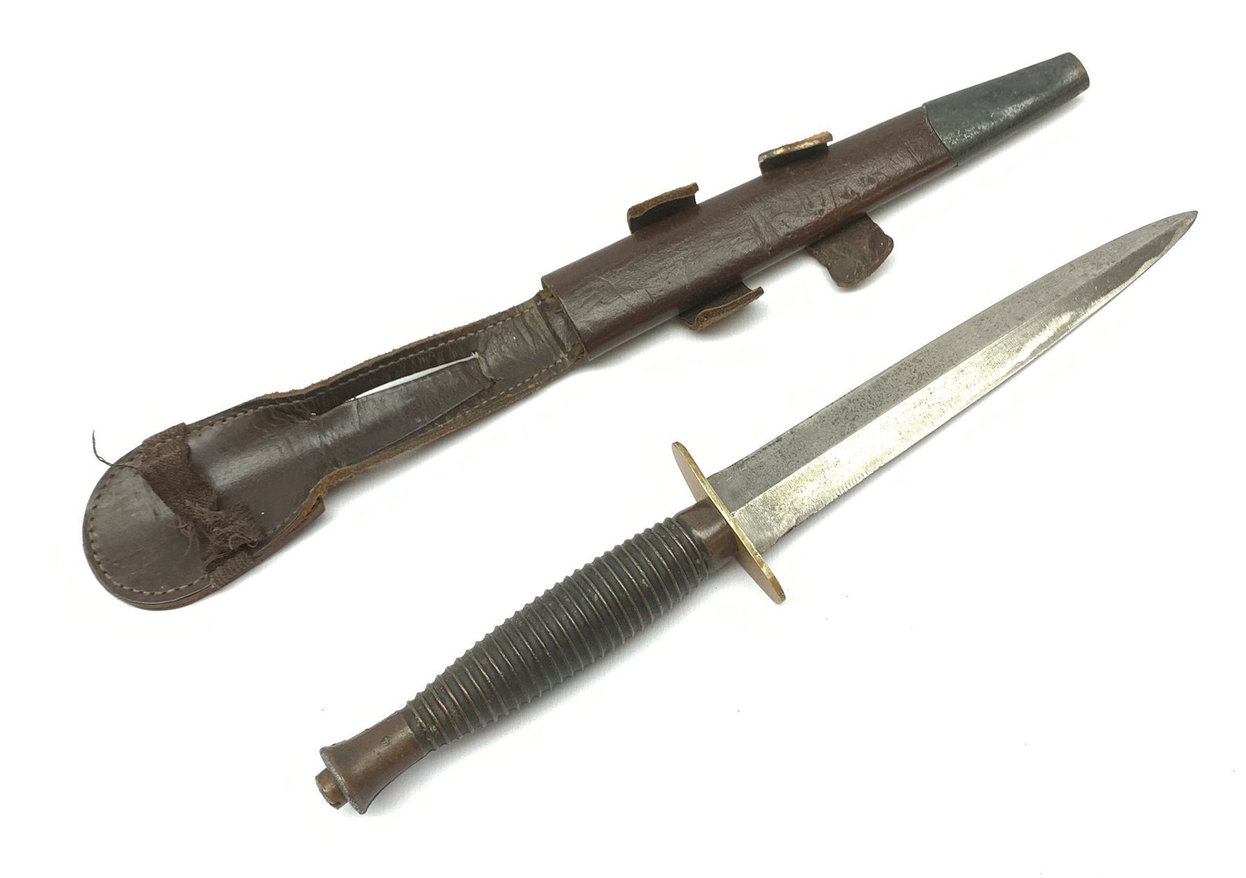 British Fairbairn-Sykes type 3rd pattern Commando fighting knife with unmarked 17cm double edged blade, oval brass cross-guard and ringed grip, in brown leather scabbard 32cm overall