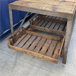 Large reclaimed industrial wrought metal and pine table, pine plank top on wrought metal base, the undertier fitted with wooden storage trays 