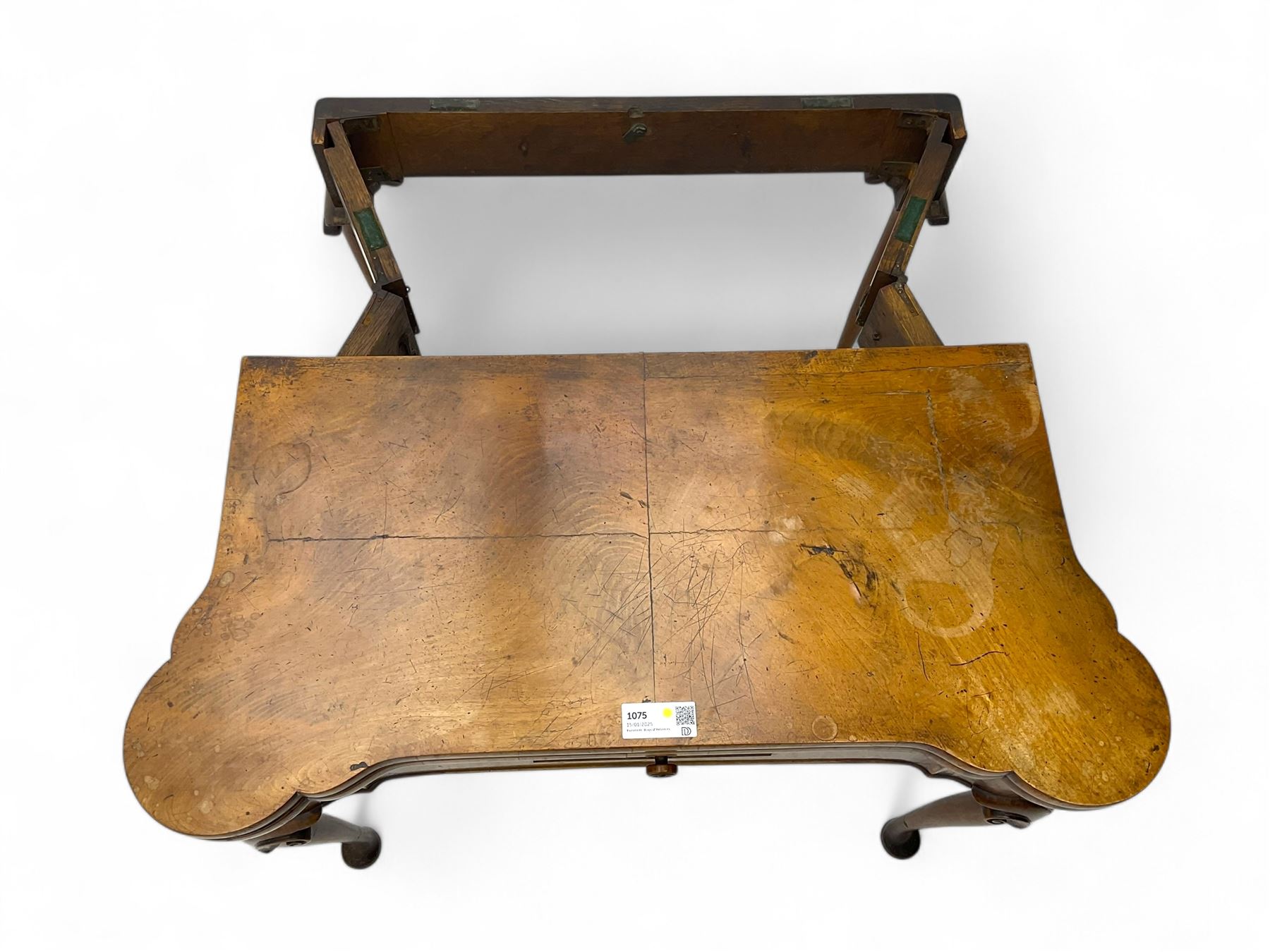 Georgian walnut fold-over card table, shaped rectangular top opening to reveal a baize-lined surface, supported by a concertina pull-out rear mechanism, frieze fitted with single drawer, raised on cabriole supports with foliate carvings terminating in pad feet