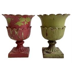 Pair of Victorian cast iron lotus garden urns, the shaped rim over lappet cast underbelly, on moulded footed base