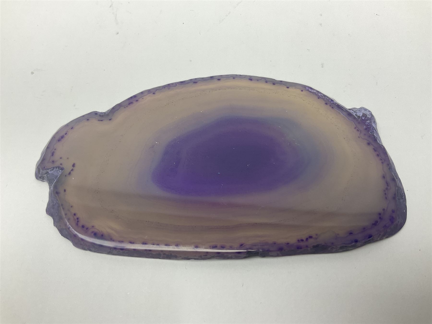 Four purple agate slices of various sizes, polished with rough edges