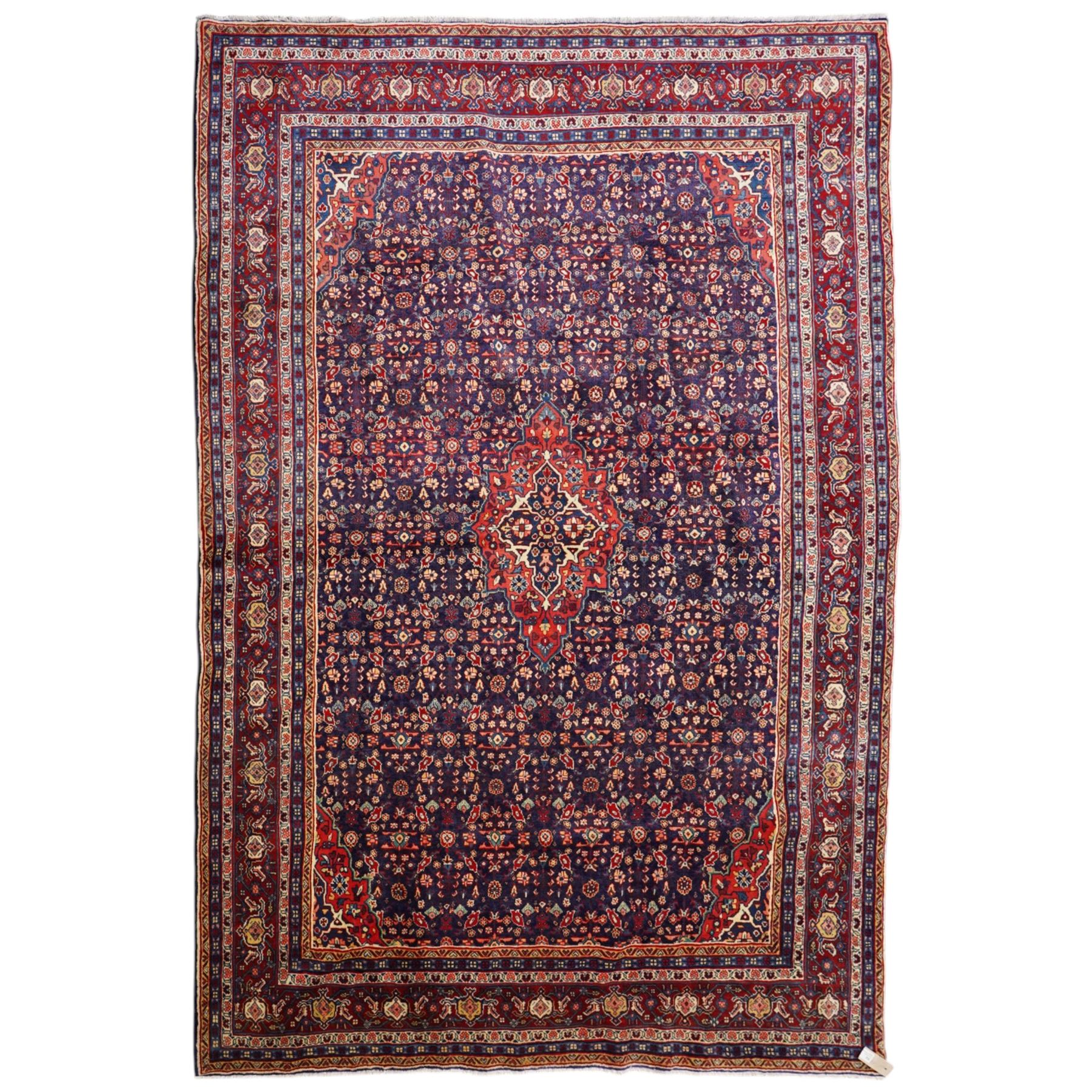 West Persian Mahal hand-knotted carpet, indigo field with central stylized angular medallion issuing an all-over Herati-inspired lattice of floral sprays, rosettes and geometric vinery in tone soft madder red, ivory and soft blue, principal border decorated with stylized palmettes, and angular vine motifs, flanked by multiple guard borders, with cotton fringe ends 