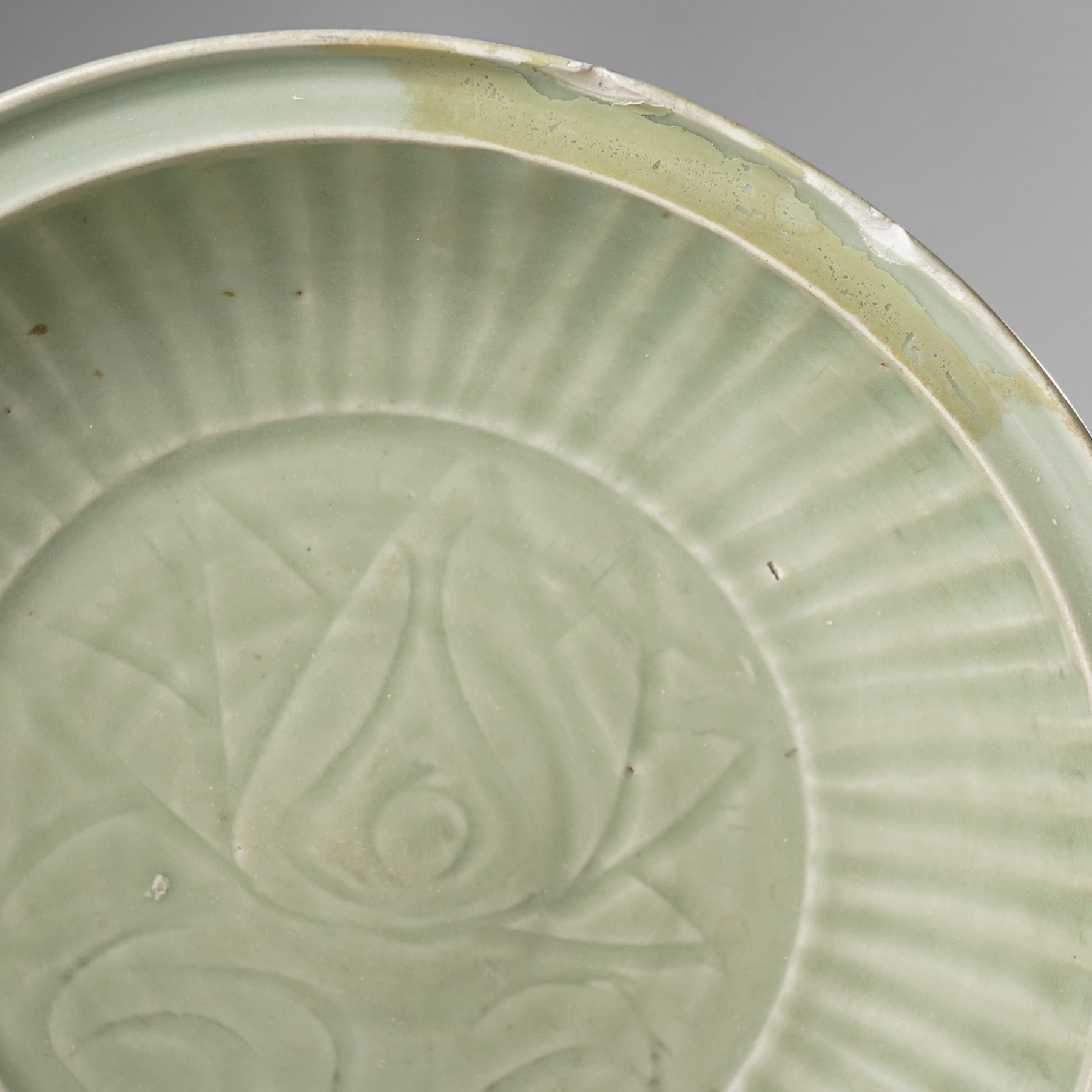 Chinese Ming dynasty Longquan celadon dish, the base carved with a lotus within a ribbed surround D35cm