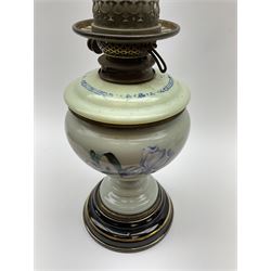 A Victorian oil lamp, with opaque glass reservoir hand painted with flowers beneath a Hinks burner and supporting a globular floral painted opaque glass shade and glass chimney, H47.5cm. 
