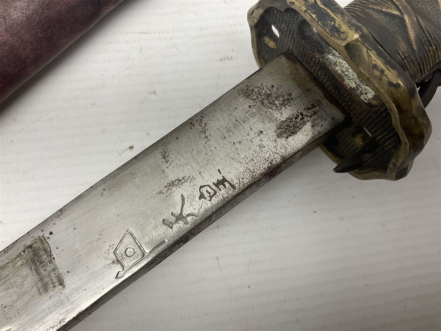 Copy of a WWII Japanese NCO sword, the 65cm slightly curving blade stamped with pseudo Japanese characters and cast brass simulated cord bound grip; in officer's leather bound field scabbard L97cm overall
