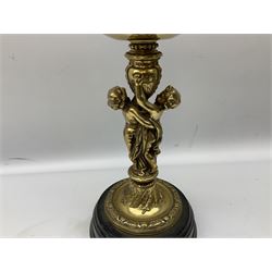 Late 19th/early 20th century brass oil lamp, the central column modelled with two cherubs, supporting the reservoir with wyrthen twist etched floral shade, raised upon circular base