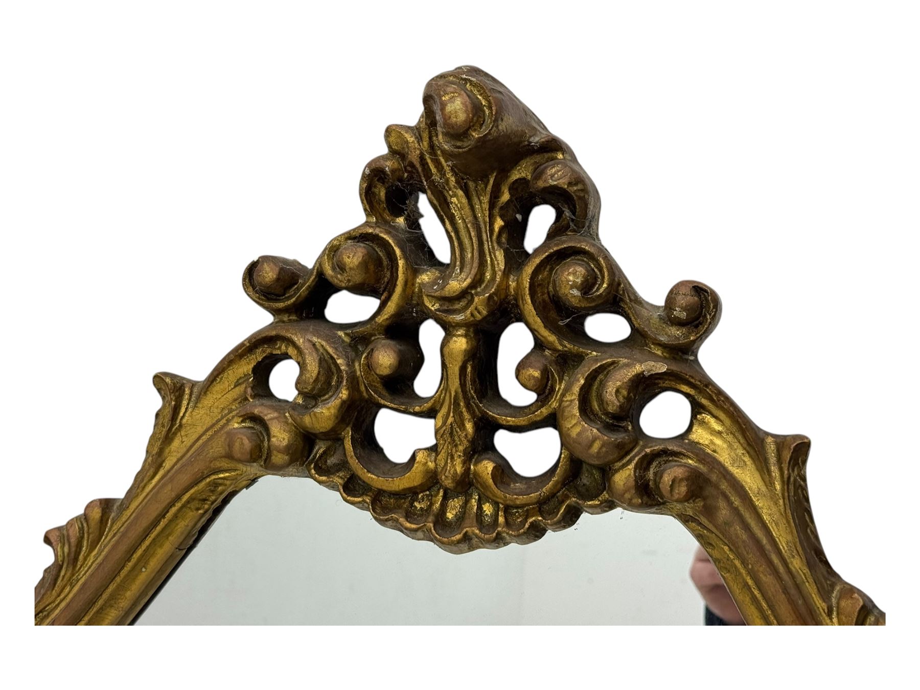 Victorian design gilt framed overmantel mirror, the arched and moulded frame adorned with scrolling foliate motifs and acanthus leaves, surmounted by a pierced cartouche, plain mirror plate, resting on a shaped base