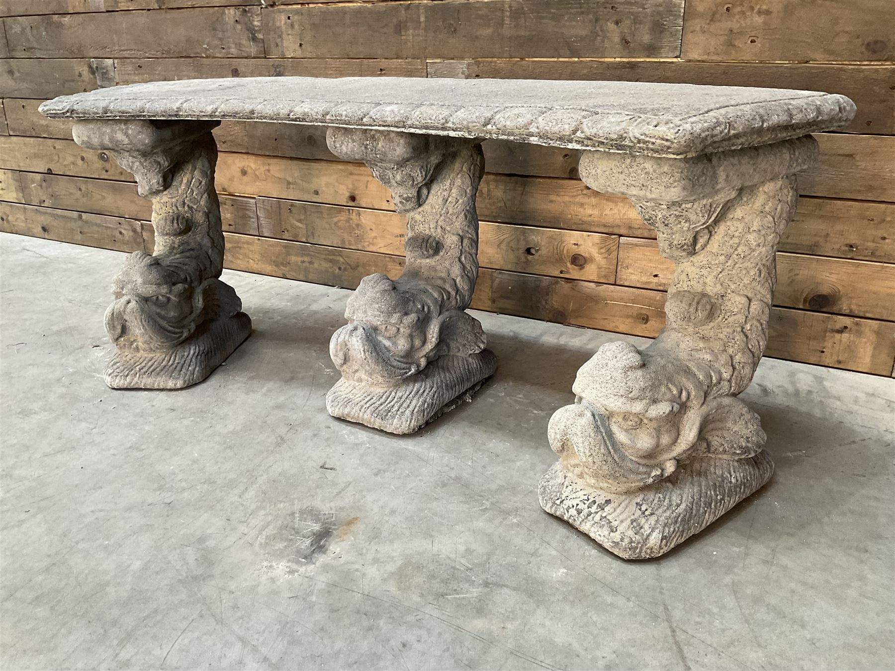 Cast stone four piece curved Dolphin bench, set with three dolphin pillars, curved rectangular slab top with detailed border
