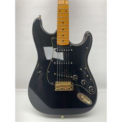 Copy of a Fender Stratocaster electric guitar in black with Wilkinson bridge, lock-in tuners, synchronised tremolo and various patent numbers; L99cm; in hard carrying case with strap and digital tuner
