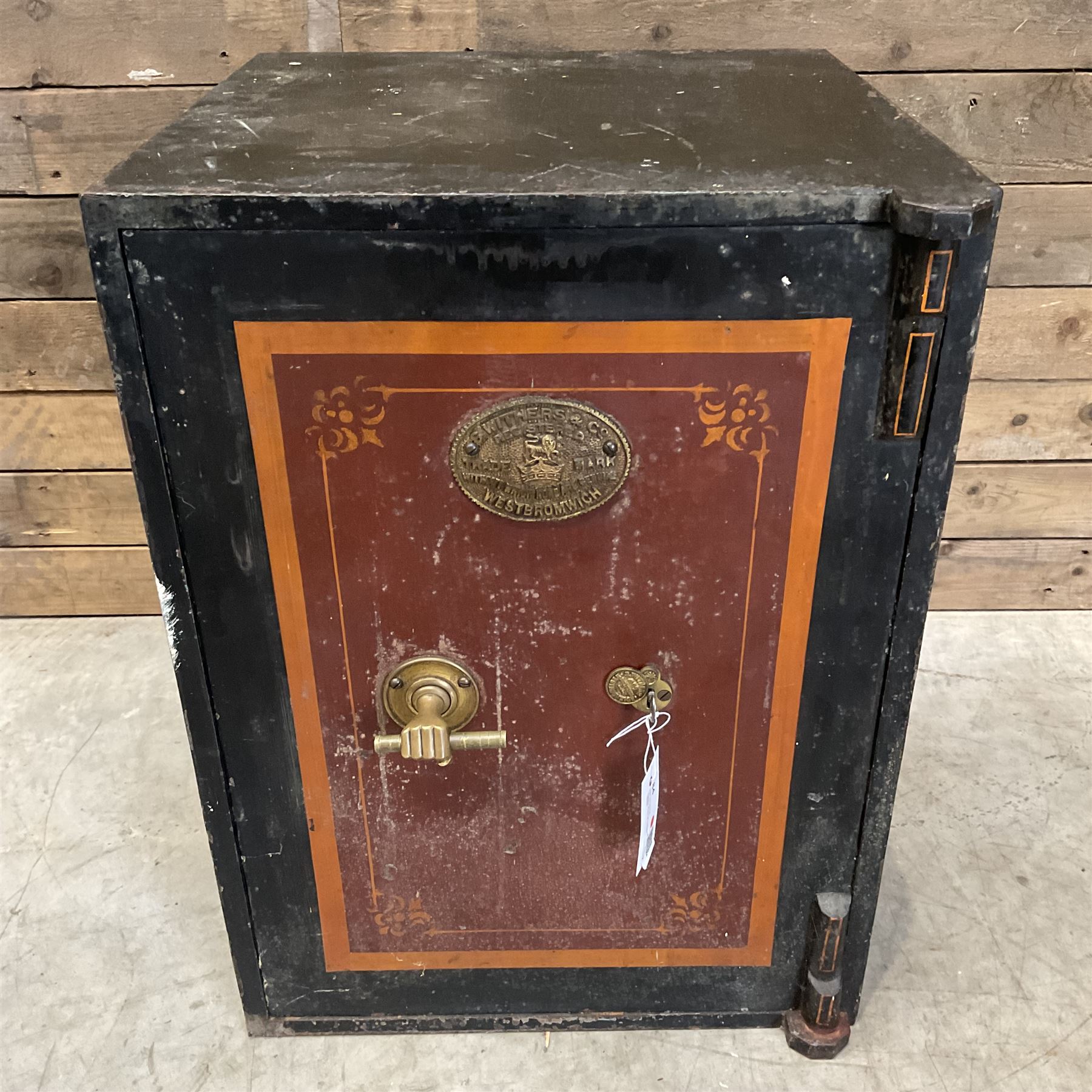 Samuel Withers & Co of West Bromwich - Victorian cast iron safe, the brass handle modelled as a clenched fist, painted in red, orange and black, with key. Ground floor delivery only, no steps.