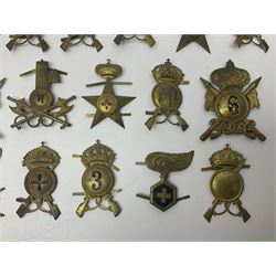 Over thirty British and Continental military metal badges; together with quantity of shoulder titles, collar dogs, rank pips, uniform buttons etc